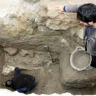 Uno de los arqueólogos trabajando en la excavación de un agujero en el solar de la Catedral de Tortosa, con la ayuda de un compañero desde la superficie.