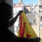 El regidor de la CUP a l'Ajuntament de Tarragona, Jordi Martí, penjant una bandera estelada a la finestra del despatx.