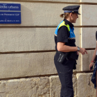 Una agente de la Guardia Urbana de Reus atiende una ciudadana en las puertas de una de las CEP de la ciudad.