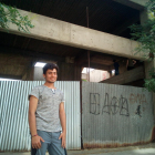 Abdulnahab Afridi, de 17 años, sonríe en la entrada del edificio, donde vive desde hace unos meses.