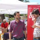 L'eurodiputat Ernest Urtasun, mirant el seu telèfon mòbil, amb el candidat número 2 pel Senat d'En Comú Podem per Tarragona, el tortosí Jordi Jordan, amb la carpa de la coalició al fons.