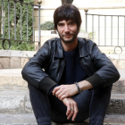 El músico y compositor, Joan Masdéu, sentado en unas escaleras de la calle de las Peixateries de Reus.
