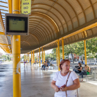 Una passatgera al costat de la pantalla d'informació de la línia Reus-TGN, a l'Estació d'Autobusos.