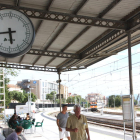 El rellotge de l'estació de Tortosa mentre arriba un dels trens des de Barcelona amb retard.