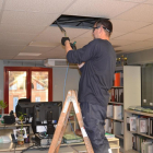 Un operari canvia els llums de les oficines municipals del Mercat Central de Reus.