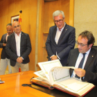 El conseller de Territori i Sostenibilitat, Josep Rull, fullejant el Llibre d'Honor de l'Ajuntament de Tarragona, sota la mirada de l'alcalde, Josep Fèlix Ballesteros.