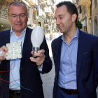 El alcalde de Reus, Carles Pellicer, y del concejal de Medio Ambiente, Daniel Rubio, mostrando la bombilla que se sustituirá por luz led, en la calle de Llovera de Reus, una de las calles que renovará alumbrado.