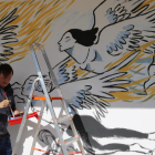 Pla mig d'Ignasi Blanch pintant el mural a Roquetes. Imatge del 5 de novembre de 2017