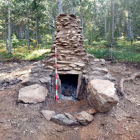 Les restes de l'estructura del forn de reducció de ferro ja excavat, i un possible segon forn en segon terme, al municipi d'Alins.