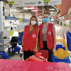 Dos voluntarias recogiendo material escolar en el Carrefour de les Gavarres.