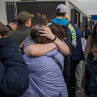 Refugiats s'abracen després d'arribar a l'estacionament d'un centre comercial a Zaporiyia.