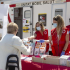 Imatge de dues volutàries de la Creu Roja atenent a dues dones d'edat avançada.