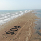 El assistens a l'acte del MOLDE han configurat les lletres SOS a la platja del trabucador.