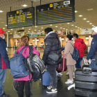 Un grupo de pasajeros miran el tablero de salidas del aeropuerto de Reus.