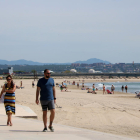 Pla obert d'una família caminant pel passeig marítim de la Pineda, a Vila-seca.