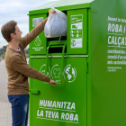 UN ciutadaà depositando ropa utilizada en un contenedor de Humana.