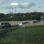 MIlitars rusos escuchan los buses que traskkades a los soldados ucranianos evacuados de la planta de Azovstal.