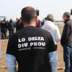 Un assistent a l'acte organitzat pel MOLDE a la platja del Trabucador llueix una samarreta en defensa del Delta.