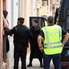 Una mujer detenida saliente de una de las viviendas, al lado de agentes de la Guardia Civil, en Amposta, durante una operación contra el tráfico de drogas, este 12 de mayo de 2016