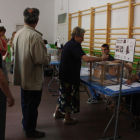 Tres electores hacen cola ante la mesa electoral en el colegio de IES Tarragona de Tarragona el 26 de junio de 2016