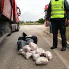 Detalle de los fardos de droga que se encontraron en el interior de un vehículo en un control custodiados por un agente de la Guardia Civil.