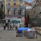 Imagen de la plaza de los Sedassos vacía, con un grupo de turistas observando las obras del Circo.