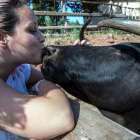 Anna Sánchez, coordinadora de premsa del Hogar Animal Sanctuary, fent un petó a la vaca Margarita.