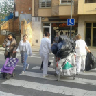 Empleades traslladen les bosses a l'altre costat de la calçada.