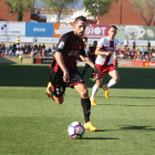 Jorge Miramón condueix la pilota durant un instant de l'enfrontament d'aquest diumenge, sota la mirada d'un oponent de l'Osca.
