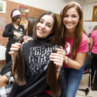 Una alumna sosteniendo la cola de pelo que se ha cortado para darla a la fundación Mechones solidarios.