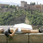 Una turista toman el sol en la ciudad de Granada.