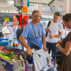 El comerciant, ahir al matí, a Corsini, amb dos turistes francesos que compraven roba.