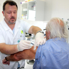 Un enfermero poniendo la vacuna de la gripe a un paciente.
