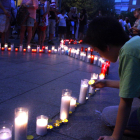 Imatge d'arxiu d'un nen posant espelmes pels assassinats masclistes de dues dones i dos menors a Castelldefels el 2015.