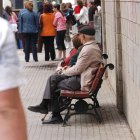 Imagen de archivo de personas mayores sentadas en un banco.