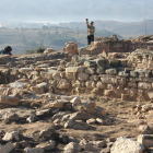 Les restes del jaciment iber de Gandesa amb dos arqueòlegs treballant al fons.