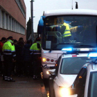 Un grupo de escolar bajando del autocar a las puertas de l'IES Roquetes mientras los Mossos D'Esquadra inician el control de los vehículos.