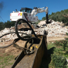 La máquina excavadora sobre los escombros de la casa destruida del matrimonio de Alfara de Carles. Imagen del 20 de marzo de 2017 (horizontal)