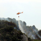 Plano general de un helicóptero de los Bomberos descargando agua en un incendio que se ha originado en Picamoixons, en el Alt Camp, el 30 de mayo del 2017.