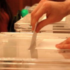Un elector depositando su voto en la urna.