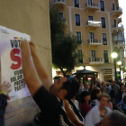 Un participant a l'enganxada col·locant un dels cartells favorables al Sí.