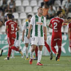 Markovic, del Córdoba, es lamenta per la golejada. Al fons de la imatge, jugadors del Nàstic celebrant un dels gols anotats diumenge.