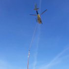 El helicóptero realizando los trabajos en la línea eléctrica de difícil acceso.