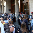 El portal del Departamento de Economía y Finanzas, en la Rambla de Cataluña de Barcelona, custodiado por Mossos y Guardia Civil, lleno de periodistas y ciudadanos con carteles de 'democracia'