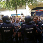 La policia espanyola envoltant la seu de la CUP, mentre simpatitzants criden en contra de l'actuació i en favor de l'1-O.