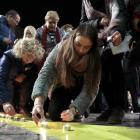 Imatge d'una noia encenent una espelma davant de l'Ajuntament de Tarragona.