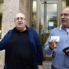 Ramon Pàmies i Joan Moncusí mostrant les seves targetes de crèdit després de retirar 150 euros en un caixer del BBVA de la plaça Prim de Reus.