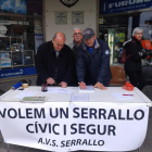 Dos veïns signen el document, a la mesa situada al raser de la Llotja del Serrallo.