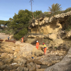 Els operaris treballant, ahir, en la trituració de les roques, a la platja del Fortí d'Altafulla.