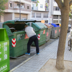 Imatge d'una persona regirant els contenidors a Reus.